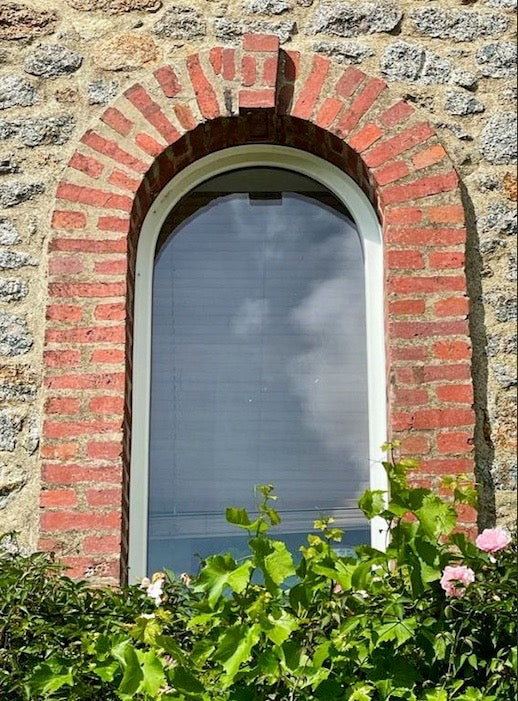 Un bâtiment en brique avec une grande fenêtre cintrée photo